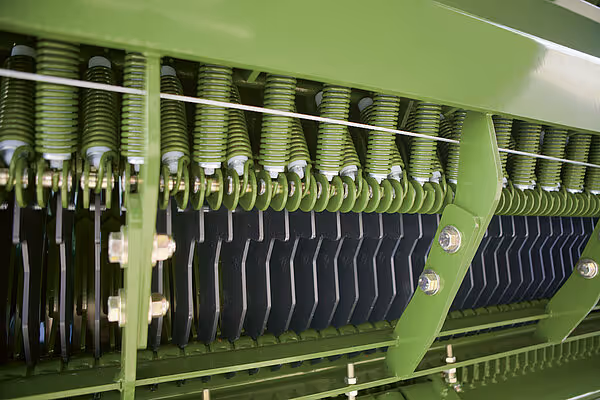 Detaljert visning av rekka med mange kniver og fjærer montert på høstmaskinen.