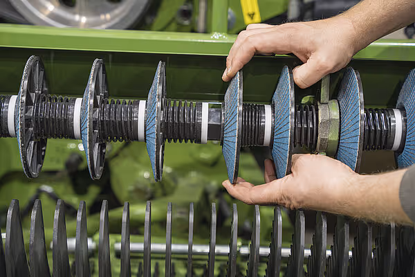 Nærbilde av rotorakselen med blå knivdisker og metallspiral som komponenter i kuttermekanismen.