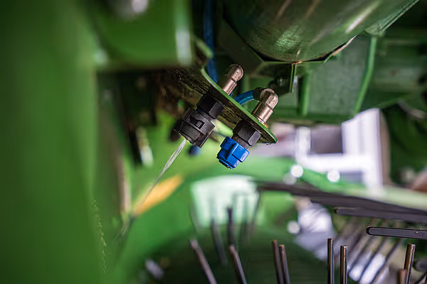 Nærbilde av hydrauliske ventiler og ledninger på KRONE RX høstmaskin i grønt og sort.