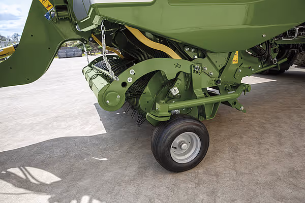 Detaljbilde av pressemekanisme på KRONE RX kornvogn viser valser, kjettinger og drivsystem montert under presskammeret.