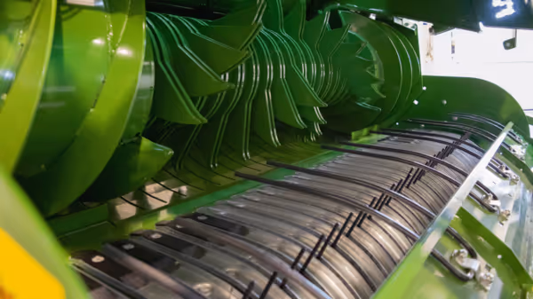 Nærbilde av rotoren i rundballpressen med rader av metalltabber som brukes til å forme og presse rundballene.