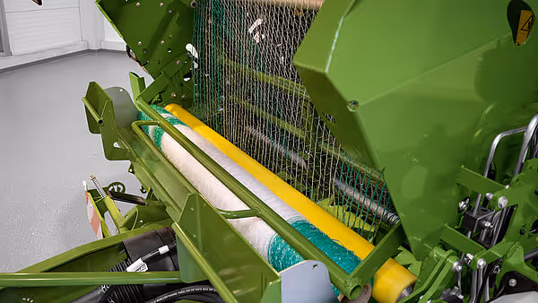 Nærbilde av oppsamlingskammeret på en KRONE VariPack rundballpresse med gul og grønn farge.