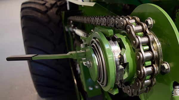 Nærbilde av kjettingdrift og roterende mekanisme på KRONE Varipack Plus rundballpresse.