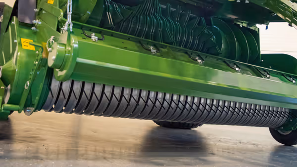 Innvendig view av KRONE VariPack Plus rundballepresse som viser kammerets metallplater og rotormekanisme i grønn farge.