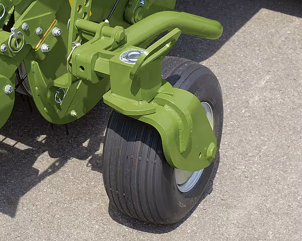 Nærbilde av pressens hjul og understell i grønn farge. Det brede hjulet har lavt trykk for å redusere jordkomprimering.