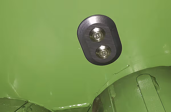 To LED-arbeidslamper montert på en grønn landbruksmaskin. Lampene har runde former og er festet med justerbare fester.