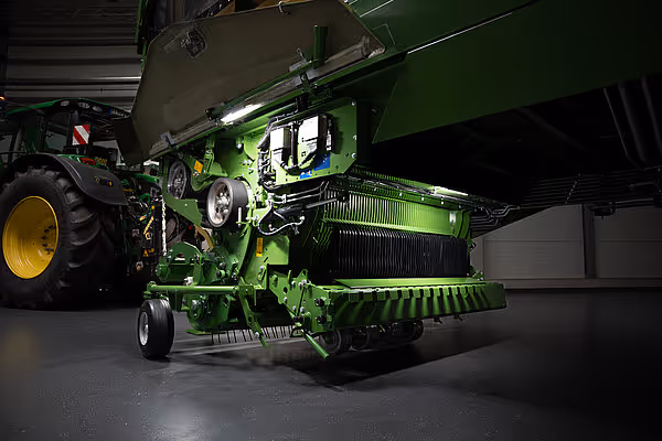 KRONE ZX høstmaskin montert på traktor, viser pikerullemekanisme og samleplass under drift i verksted.