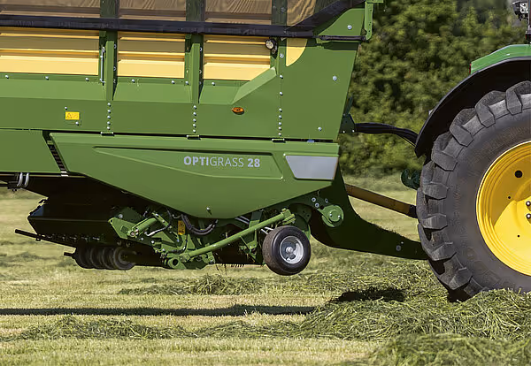 Krone Optigrass 28 høstingsmaskin med løftet slåtteapparat på grønt chassis, sett fra siden på eng.
