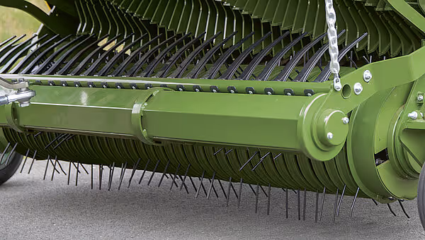 Detaljvisning av rotorklipper med symmetrisk arrangement av slåkniver og central drivenhet montert på grønt rammeverkstøy.