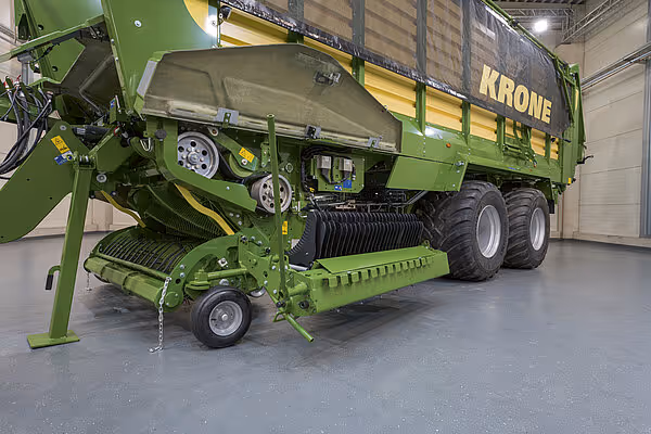 KRONE ZX rotorklipper montert under grønn Krone rundballepers i lagerhall, med klipperen i frakoblet posisjon.