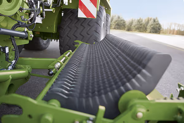 Sorterings- og leveringsmekanisme på KRONE ZX høstmaskin, viser transportbåndet i drift på veien.