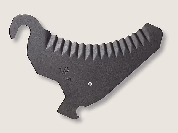 Løftekam av svart stål med karakteristisk hakform, designet for å løfte og transportere halm eller høy i pressemekanismen.