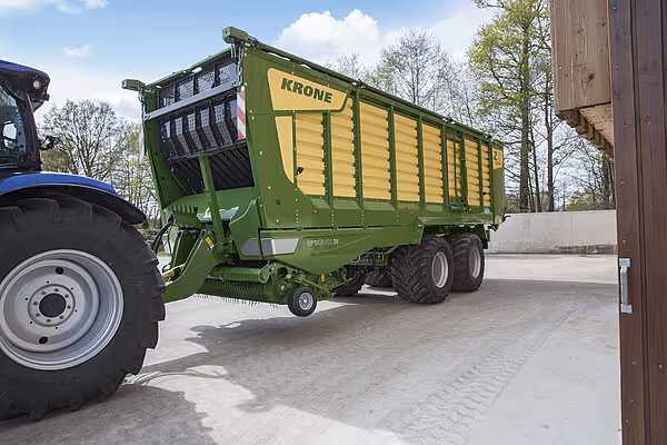 KRONE ZX silokjerre med grønt og gult design presentert på betongflate ved siden av traktor.