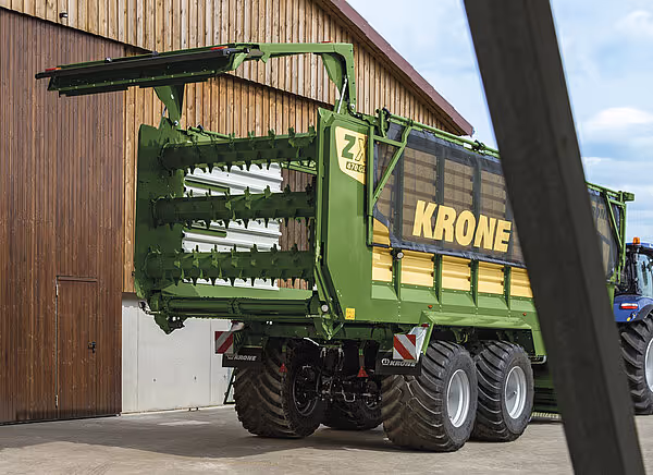 KRONE ZX silokjerre med fullt åpen fyllingsluke og internal spredningsmekanisme presentert foran bygning.