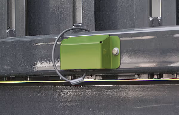 Grønt låsehåndtak med kabler på siden av KRONE ZX siloutlastingsvogn.