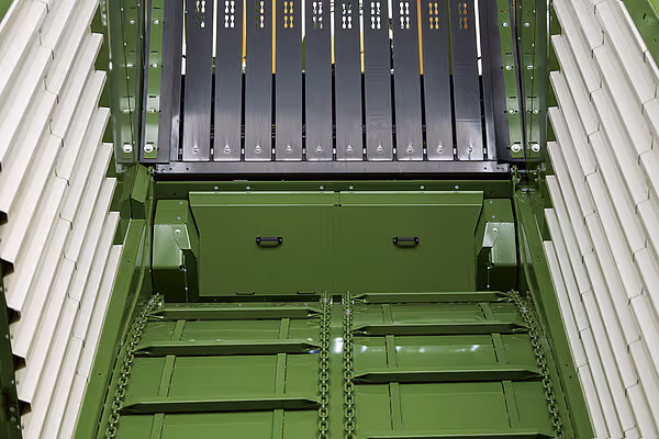 Innsidebilde av høstevognens lastkasse som viser rullebroene, langsgående stenger og nedfällbar bakvegg.