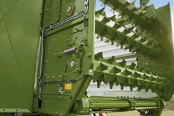 Detaljbilde av åpnet høylaster-side på KRONE ZX-vogn viser hydraulisk mekanisme og låsesystem med nettingverk.