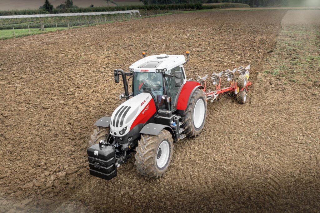 STEYR 6175 Impuls CVT traktor sett bakfra mens den pløyer en åker.