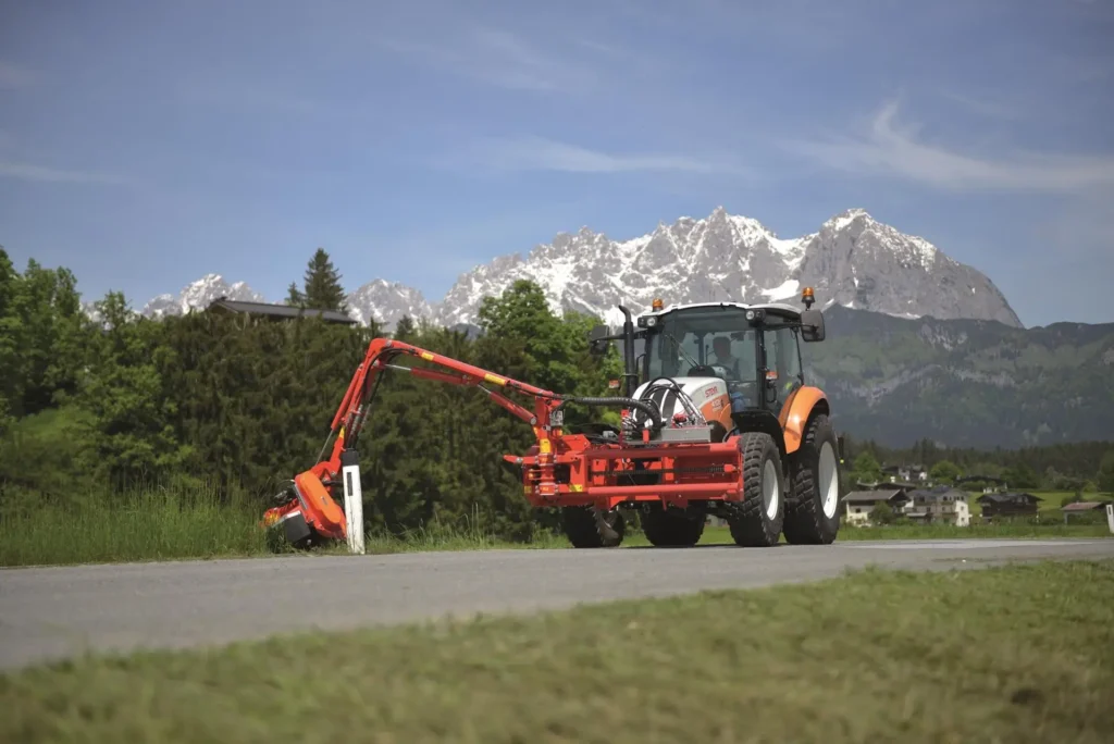 En STEYR 4110 Kompakt traktor jobber med veislått.