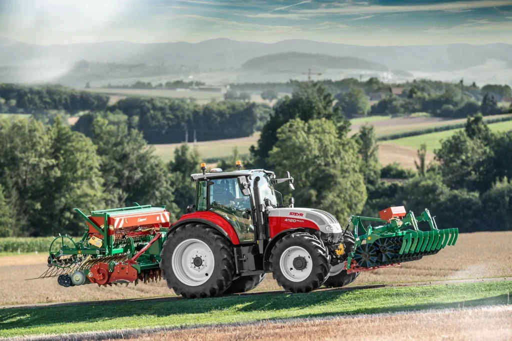 Steyr 4120 Multi-traktor med såmaskin og harv i en åker.