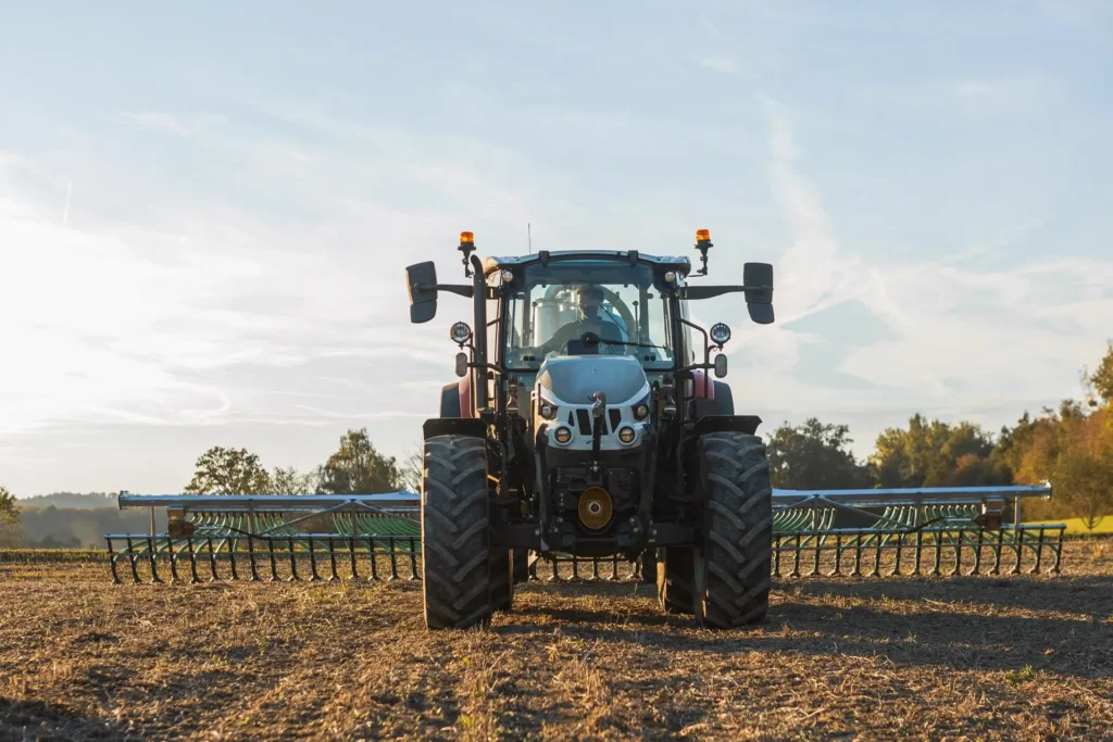 Steyr Plus-traktor sett forfra, utstyrt med bredt jordbruksredskap.