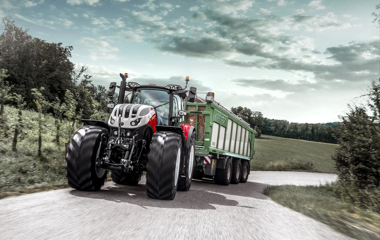 Steyr Terrus traktor på veien med en stor tilhenger.