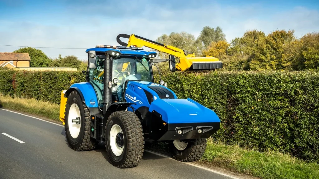 En New Holland T6 Methane Power traktor med en gulkledd hekkklipper, som viser presisjon i landskapspleie og vedlikehold.