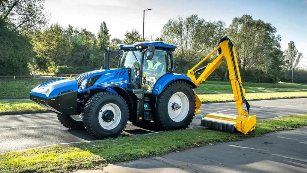 T6 Methane Power traktor utstyrt med en klippearm som trimmer hekker langs en landevei, et eksempel på tilpasningsdyktighet for ulike arbeidsoppgaver.