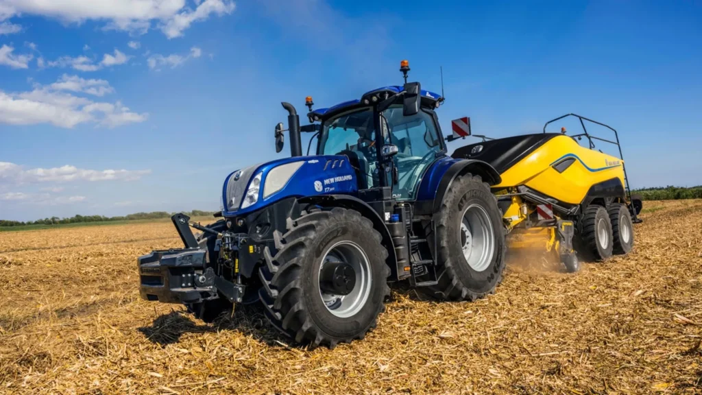 En New Holland T7 LWB-traktor under jordbearbeiding, med fokus på effektivitet og stabilitet på åpent jorde.