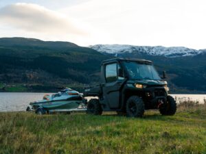 Can-Am TRAXTER sleper en båt nær innsjøen.